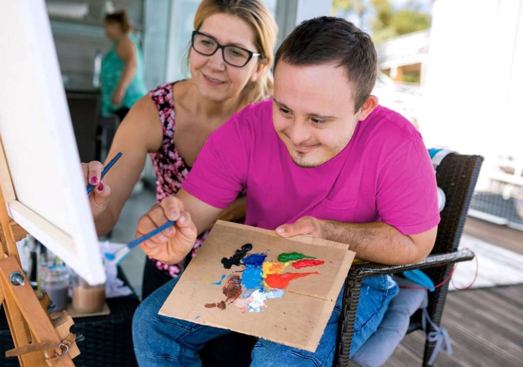 Young-man-with-Down-Syndrome-painting-with-mum-1024x724